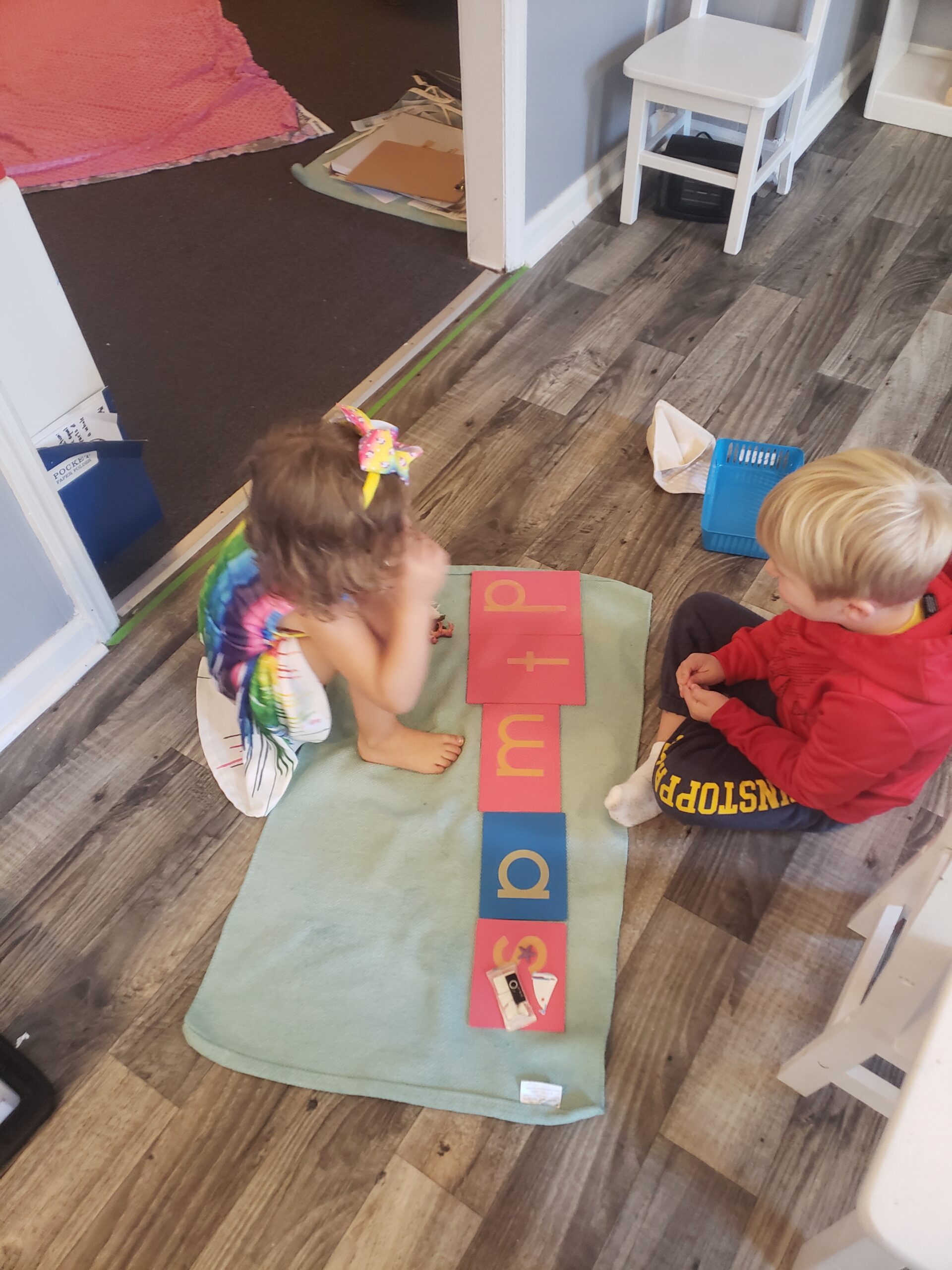 Two kids in front of a rug